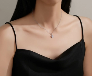 Close-up of S925 silver necklace with square emerald-cut zircon on female model