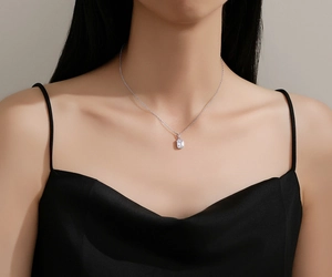 Close-up of a square cut zircon pendant necklace on a silver chain worn by a model