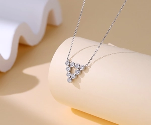 Macro detail of silver S925 triangle pendant with sparkling cubic zirconia stones