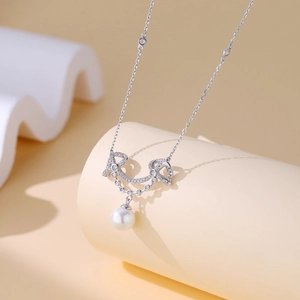 Close-up of S925 silver smiley necklace with micro-pave crystals and white pearl pendant