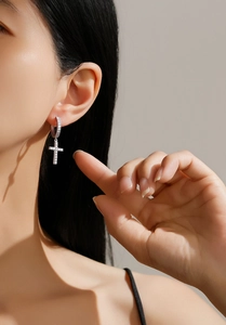 Close-up of S925 silver cross hoop earring with zircon inlay worn by a female model