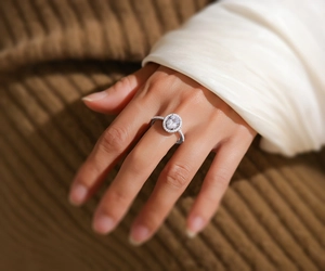 Gros plan d'une bague ovale en moissanite et argent S925 portée au doigt