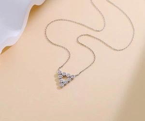 Detailed close-up of a silver triangle necklace with sparkling cubic zirconia stones