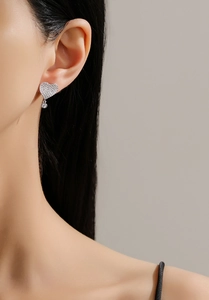 Close-up of S925 sterling silver heart stud earrings with cubic zirconia on female model