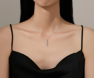 Close-up of S925 silver necklace with five vertical sparkling zircon bead pendants on model