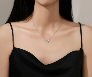 Close-up of minimalist S925 sterling silver triangle pendant with sparkling zircons