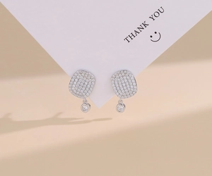 Macro shot of S925 sterling silver earrings with micro-pave zircons and round pendants