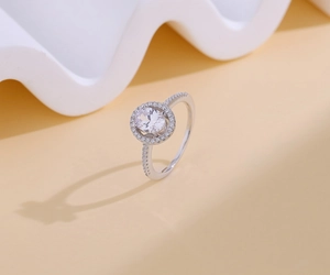 Détail d'une bague moissanite taille ovale avec monture halo et anneau pavé de diamants