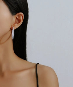 Close-up of sparkling S925 silver hoop earrings with micro-pave moissanite on model