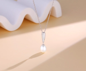 Dettaglio collana in argento s925 con ciondolo a goccia pavé e una perla bianca ovale
