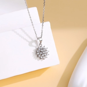 S925 sterling silver snowflake pendant necklace with cubic zirconia on white geometric block