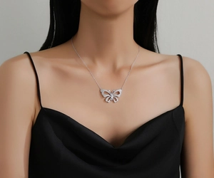 Detail of hollow butterfly pendant necklace with pavé stones on a black dress