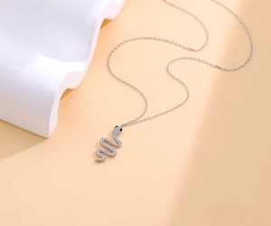 Detailed view of silver snake pendant featuring micro-pave cubic zirconia and black gem eyes