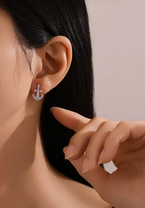 Close-up of S925 sterling silver anchor stud earrings with pavé crystals on ear