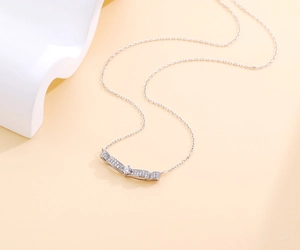Macro shot of S925 sterling silver necklace with curved sparkling diamond pendant