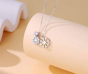 Macro view of silver snowflake pendants with zircon stones on a delicate necklace chain