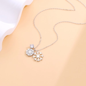 Detail view of double snowflake pendant with sparkling zircon on a silver chain