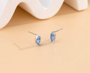Detailed macro view of S925 sterling silver hallmark on marquise blue moissanite earrings