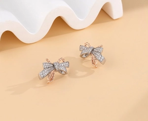 Macro view of S925 silver bow earrings with two-tone plating and pavé cubic zirconia