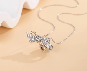 Detail of S925 silver bow pendant with rose gold rope edge and pavé zircons