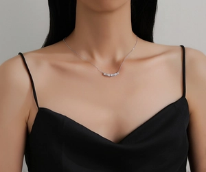 Detail shot of a minimalist S925 sterling silver wavy bar pendant with sparkling zircon stones