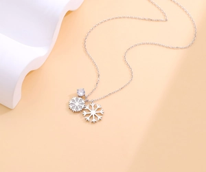 Detailed close-up of a silver double snowflake necklace with sparkling zircon crystals