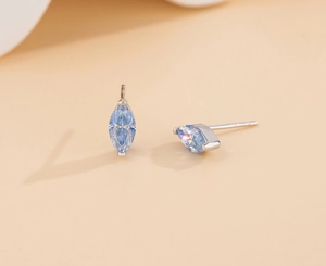 Macro shot of S925 silver stud earrings featuring marquise-cut light blue mossanite stones