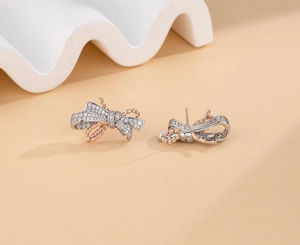 Detailed macro view of S925 sterling silver bow earrings with two-tone pave zircon crystals