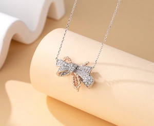 Close-up of S925 silver bow necklace with rose gold twisted texture and inlaid diamonds