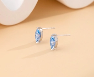 Close-up of S925 sterling silver studs with marquise-cut light blue moissanite stones