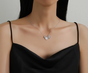 Close-up of elegant silver double snowflake necklace with diamond pendant on collarbone