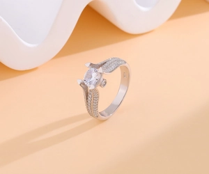 Detail of S925 sterling silver ring featuring a 4-prong set moissanite and pave accents