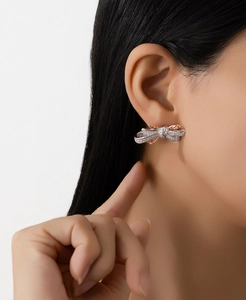 Close-up of S925 silver bow earrings with two-tone gold plating and pavé crystals