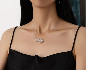 Close-up of S925 silver bow necklace with sparkling diamonds and rose gold detail