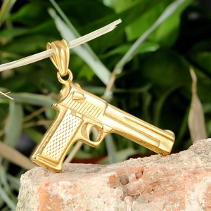 Κολιέ με χρυσό μενταγιόν Desert Eagle σε στυλ hip hop σε φόντο από φυσικό τούβλο