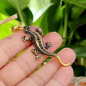 Pendentif gecko hip hop doré avec strass noirs tenu à la main pour collier homme