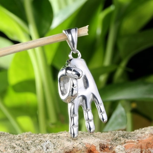 Détail d'un pendentif en forme de main argentée avec des textures nettes et un fini poli brillant