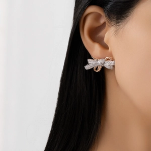 S925 sterling silver bow earrings with micro-pave crystals and two-tone plating on model