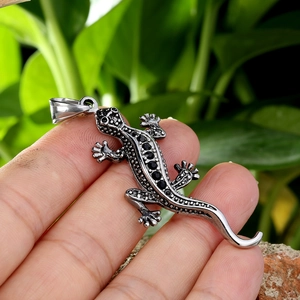 Gros plan du pendentif gecko hip hop avec pierres noires et finition argent vieilli
