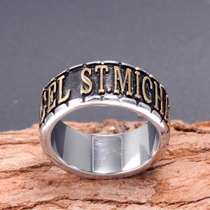 Détail d'une bague vintage en acier 316L avec relief Saint-Michel sur bois naturel