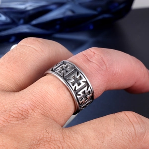Macro shot of vintage stainless steel men's ring featuring embossed iron cross patterns