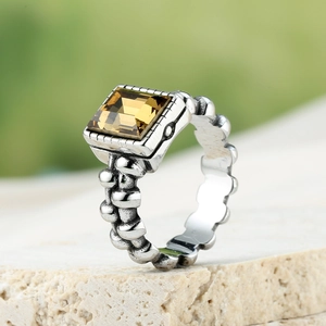 Macro-opname van vintage zilveren ring met barnsteen en kralenketting ringband