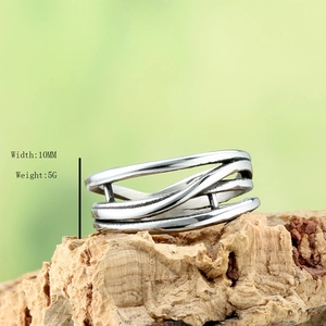 Modern irregular woven hollow silver metal ring with 10mm width on natural bark