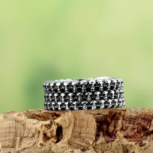 Vintage punk titanium steel skull ring with aged silver finish for men on wood background