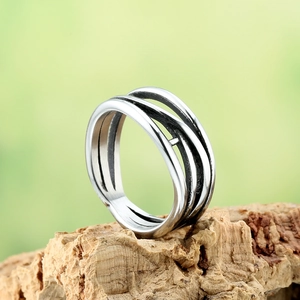 Retro multi-layer twisted silver metal ring displayed on natural wood texture background