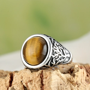 Macro shot of men's tiger eye ring with tree of life relief on silver band