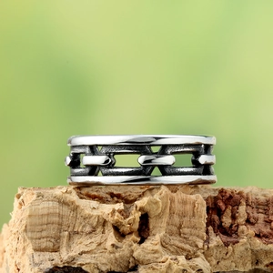 Macro shot of silver vintage chain link ring with oxidized finish on cork surface