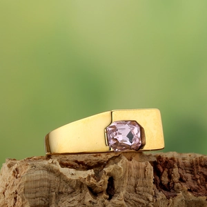 Minimalist gold ring with emerald-cut pink zircon set in a wide band on tree bark