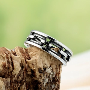 Retro titanium steel chain ring for men on rustic wood background with nature lighting