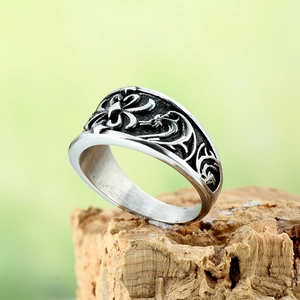Retro silver punk steel ring with intricate carvings on natural wood background
